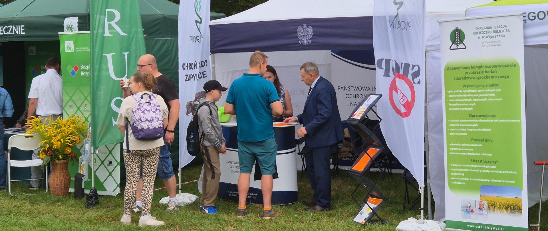 Stanowisko promocyjne WIORiN. Inspektorzy odpowiadają na pytania uczestnika uroczystości.