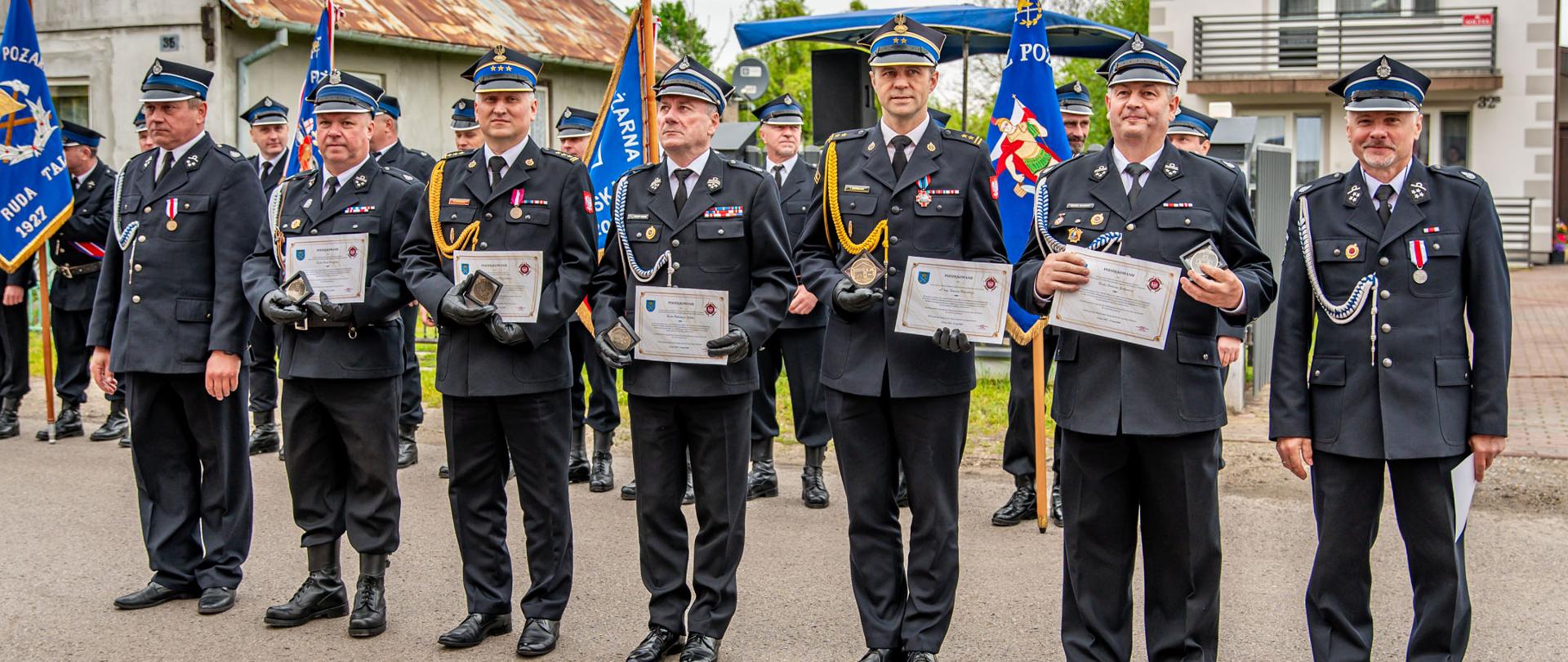 Zdjęcie grupowe 5 strażaków OSP oraz 2 funkcjonariuszy PSP. Trzymają pamiątkowe dyplomy. 