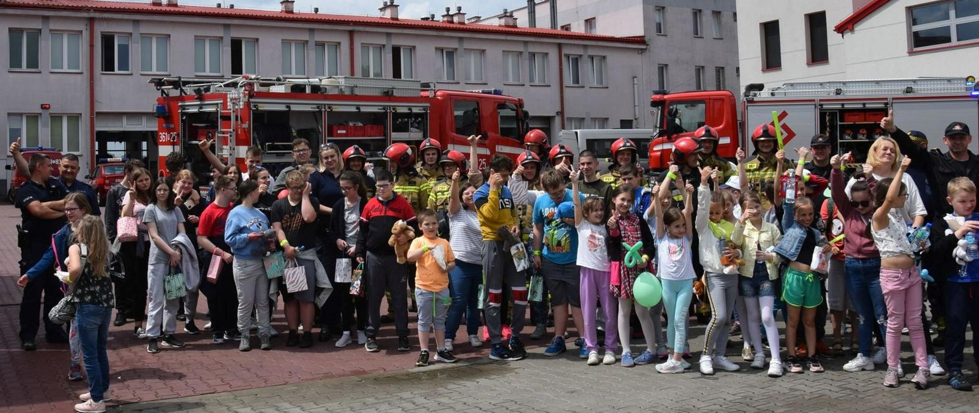 Na zdjęciu służby mundurowe oraz dzieci podczas pikniku na placu wewnętrznym KM PSP w Przemyślu 