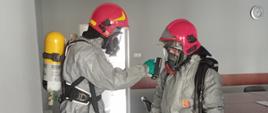 Zdjęcie przedstawia strażaków podczas szkolenia z ratownictwa chemiczno - ekologicznego. Szkolenie odbywa się na świetlicy JRG. Strażak przy pomocy urządzeń pomiarowych sprawdza substancję niebezpieczną. 