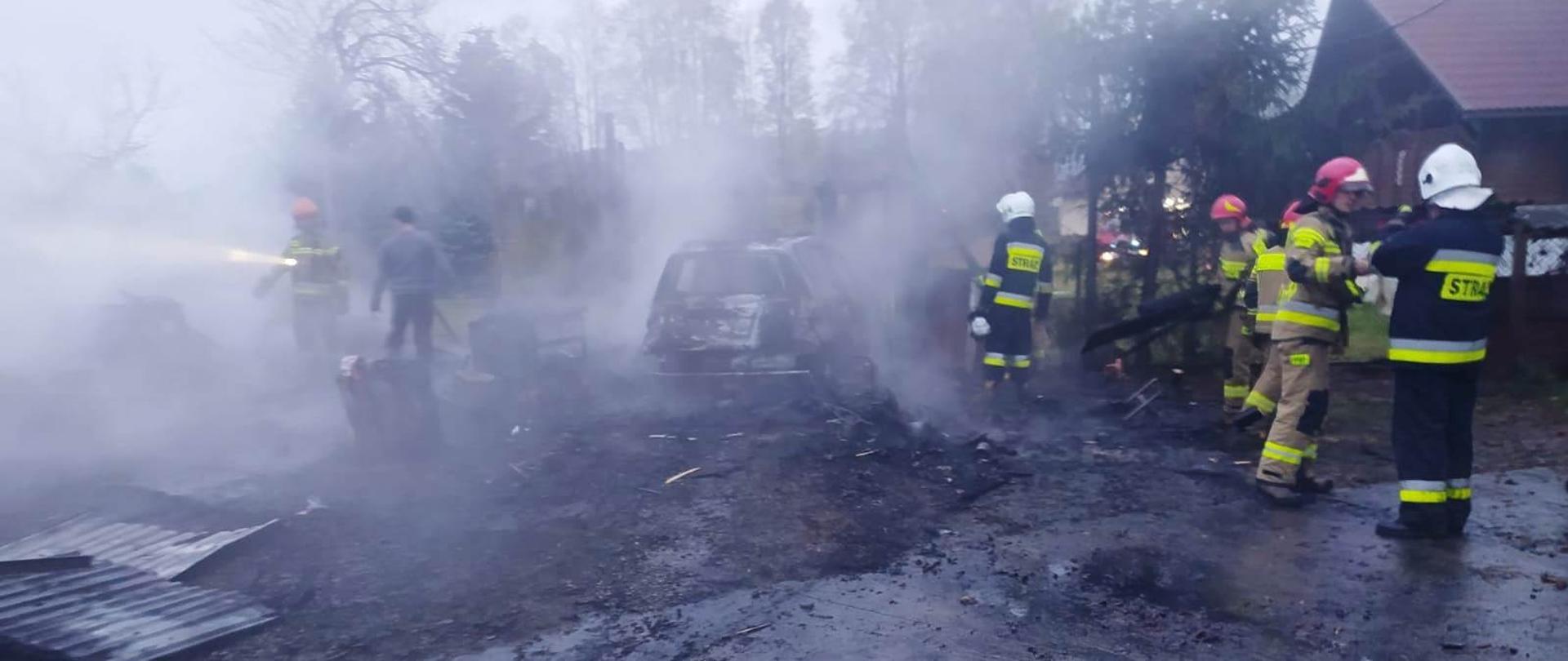 Strażacy gaszą pożar garażu.