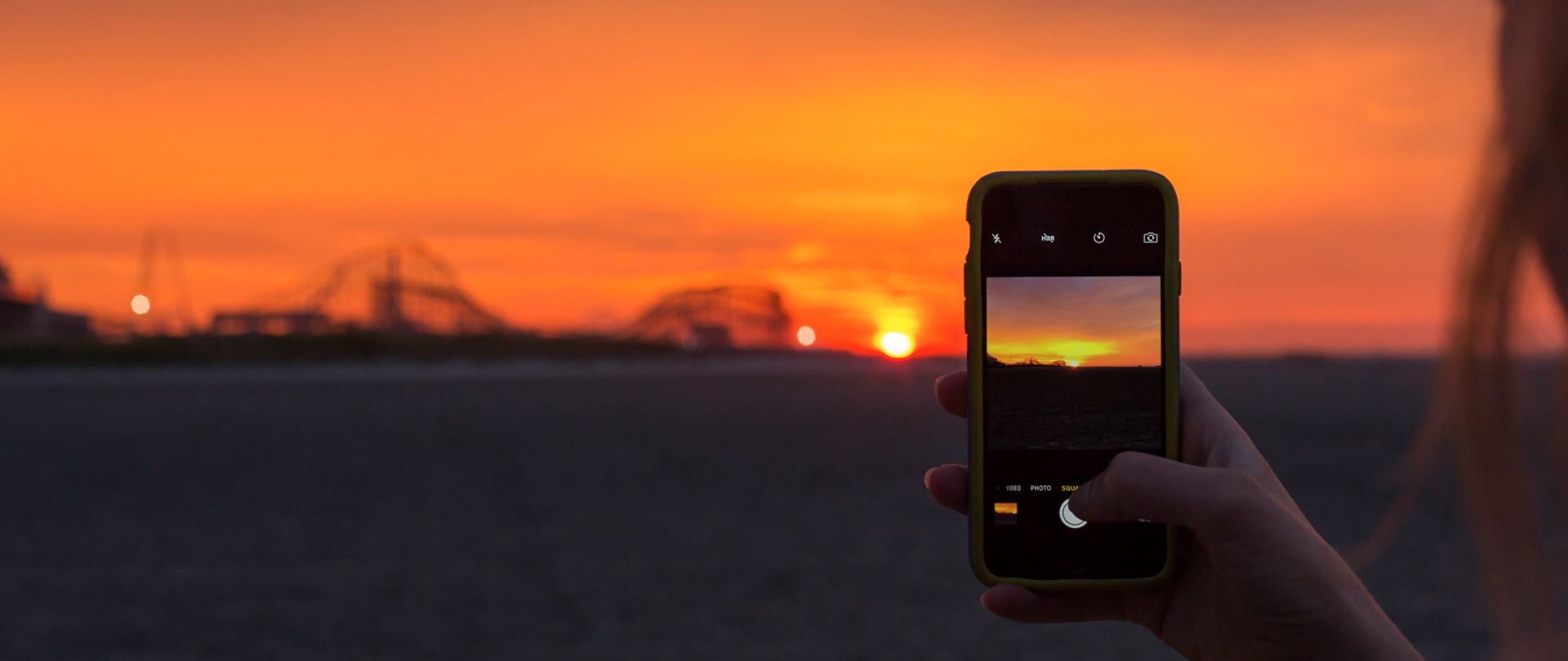 Ekran telefonu komórkowego na tle zachodu słońca.