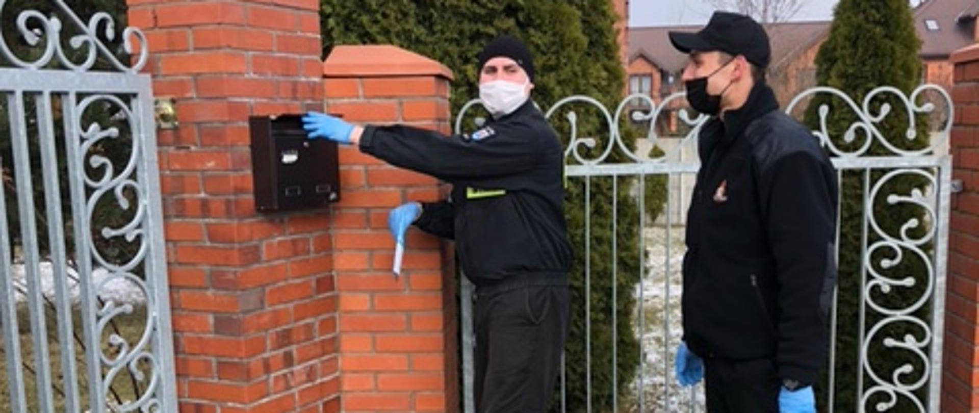 Zdjęcie przedstawia strażaków dostarczających ulotki informacyjne dotyczące szczepień przeciwko COVID-19