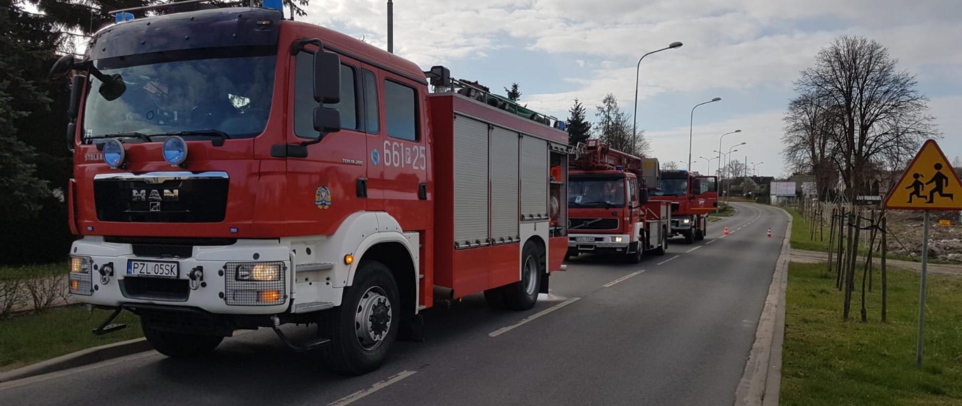 Samochody straży pożarnej ustawione wzdłuż ulicy.