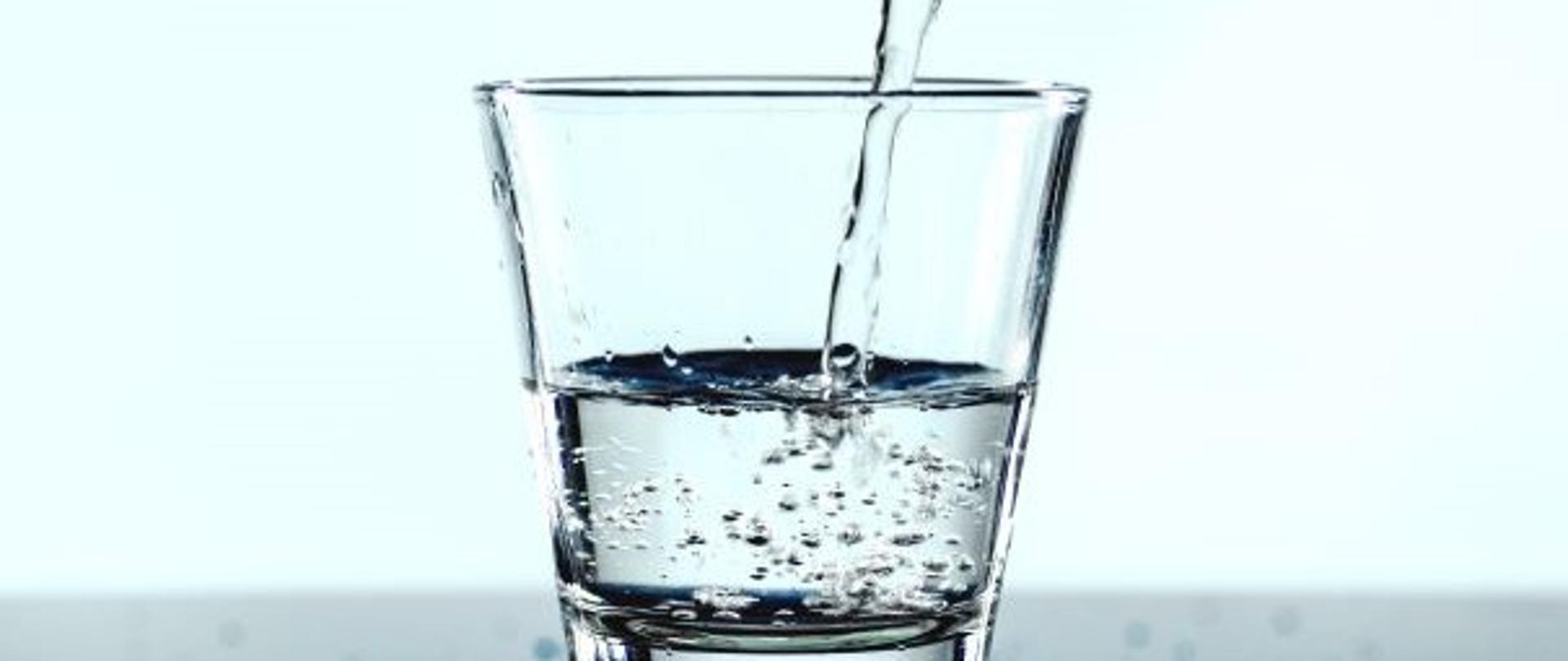 Grafika przedstawiająca szklankę wypełnioną do połowy wodą
