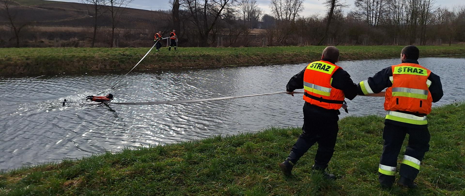 Strażacy przy pomocy węża udzielają pomocy pozorantowi