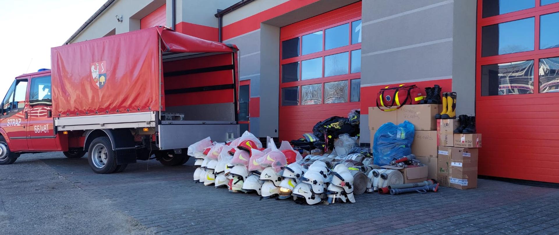 Na zdjęciu widoczny jest zgromadzony sprzęt oraz samochód strażacki 