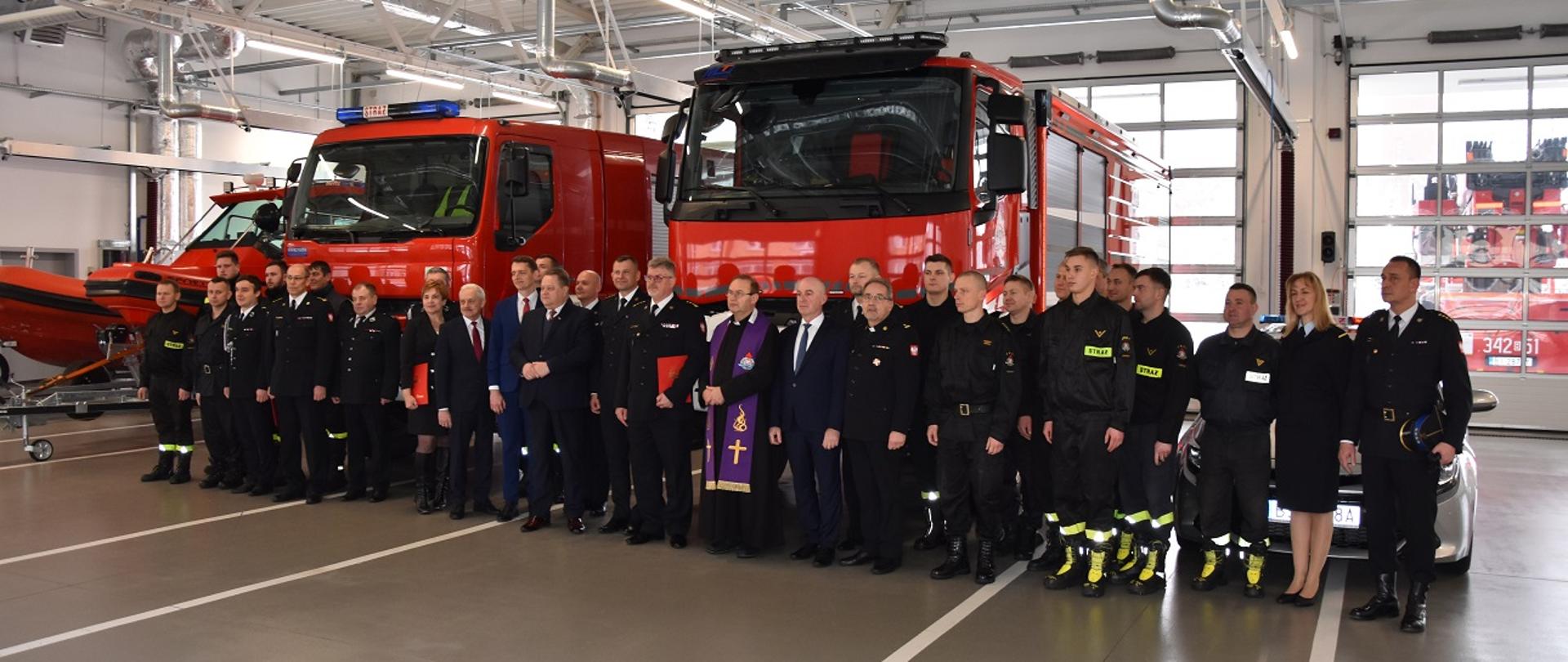Zdjęcie obrazuje strażaków i pojazdy oraz sprzęt pożarniczy