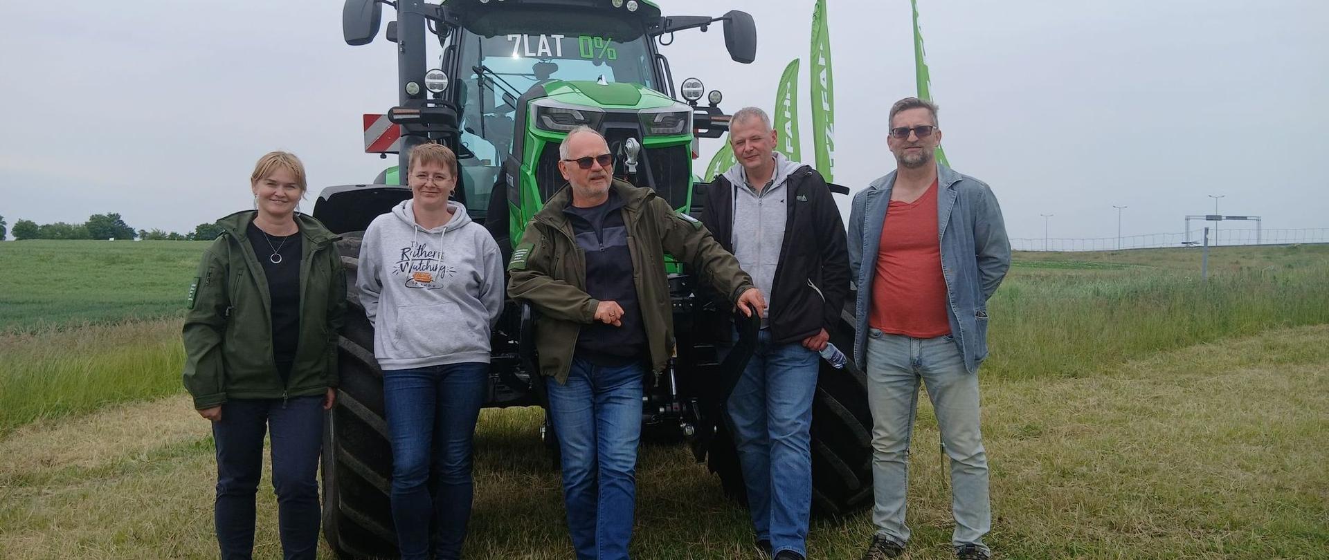 grupa 5 osób na tle nowoczesnego traktora