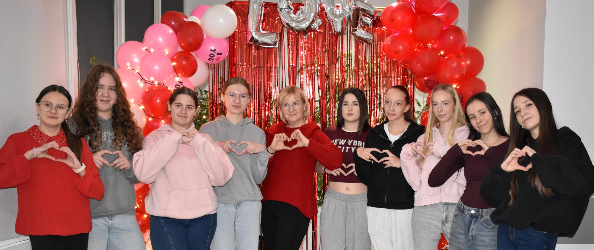 Grupa młodzieży przed walentynkową ramką z napisem LOVE