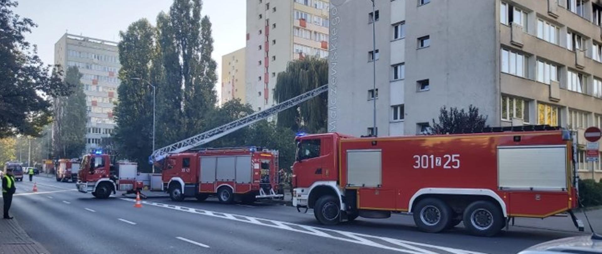 Na jezdni 3 wozy strażackie: średni, ciężki i drabina mechaniczna z JRG 1 w tle wieżowce przy ulicy Malczewskiego