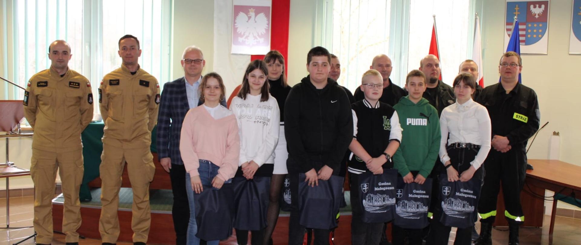 Komisja egzaminacyjna oraz pracownicy Urzędu Miasta i Gminy Małogoszcz wraz z laureatami Ogólnopolskiego Turnieju Wiedzy Pożarniczej „Młodzież zapobiega pożarom”