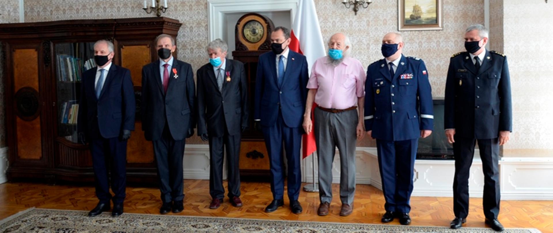 Odznaczeni za zasługi w działalności dla rozwoju polskiej gospodarki morskiej stoją w obecności zaproszonych gości, wśród nich jest pomorski komendant wojewódzki Państwowej Straży Pożarnej.