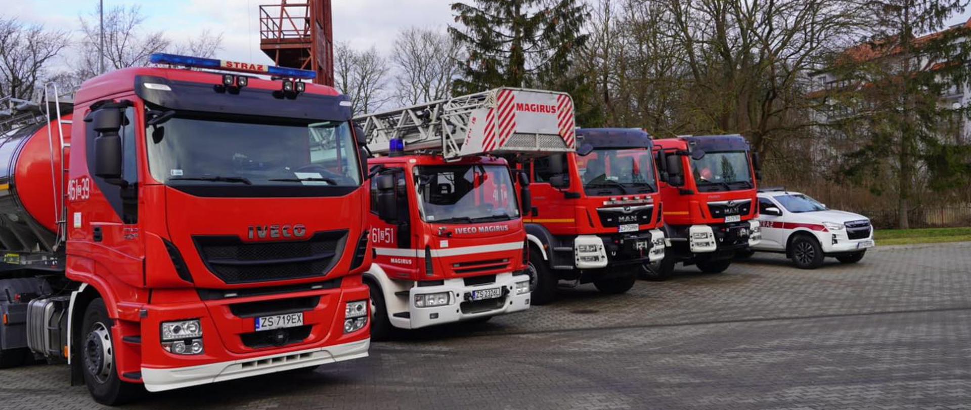 Na zdjęciu 5 samochodów ratowniczo gaśniczych, od lewej: ciągnik z cysterną,drabina,dwa samochody ratowniczo gaśnicze oraz lekki samochód ratowniczy na podwoziu ISUZU D MAX