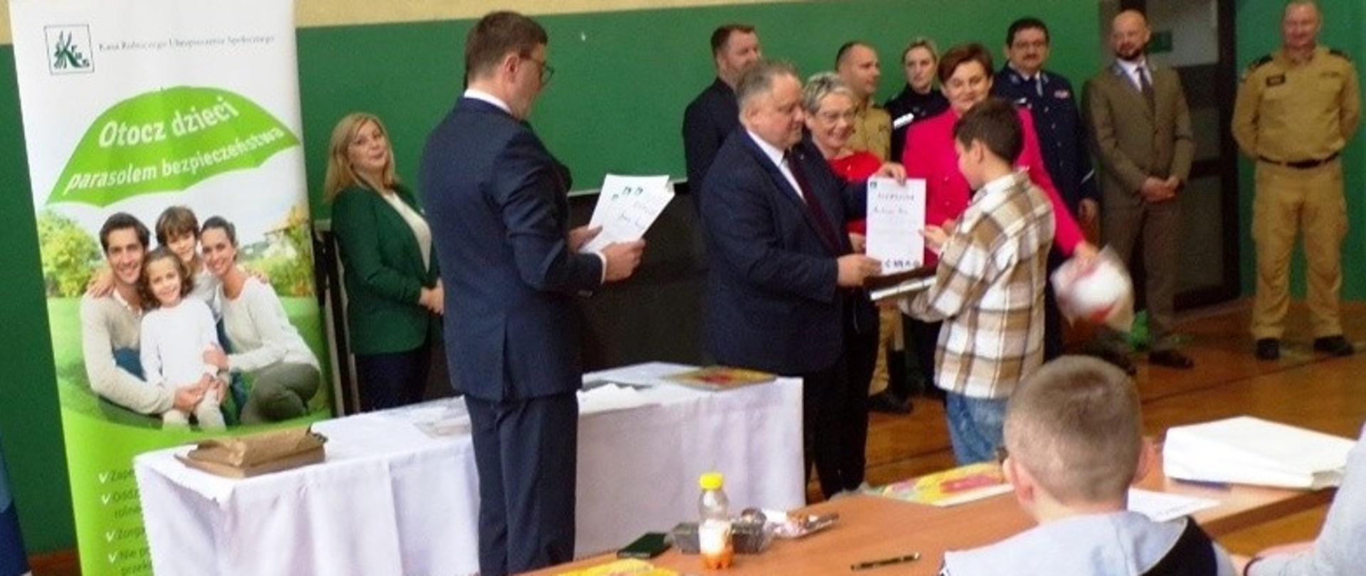 Przedstawiciele organizatorów konkursu wręczają nagrody laureatom