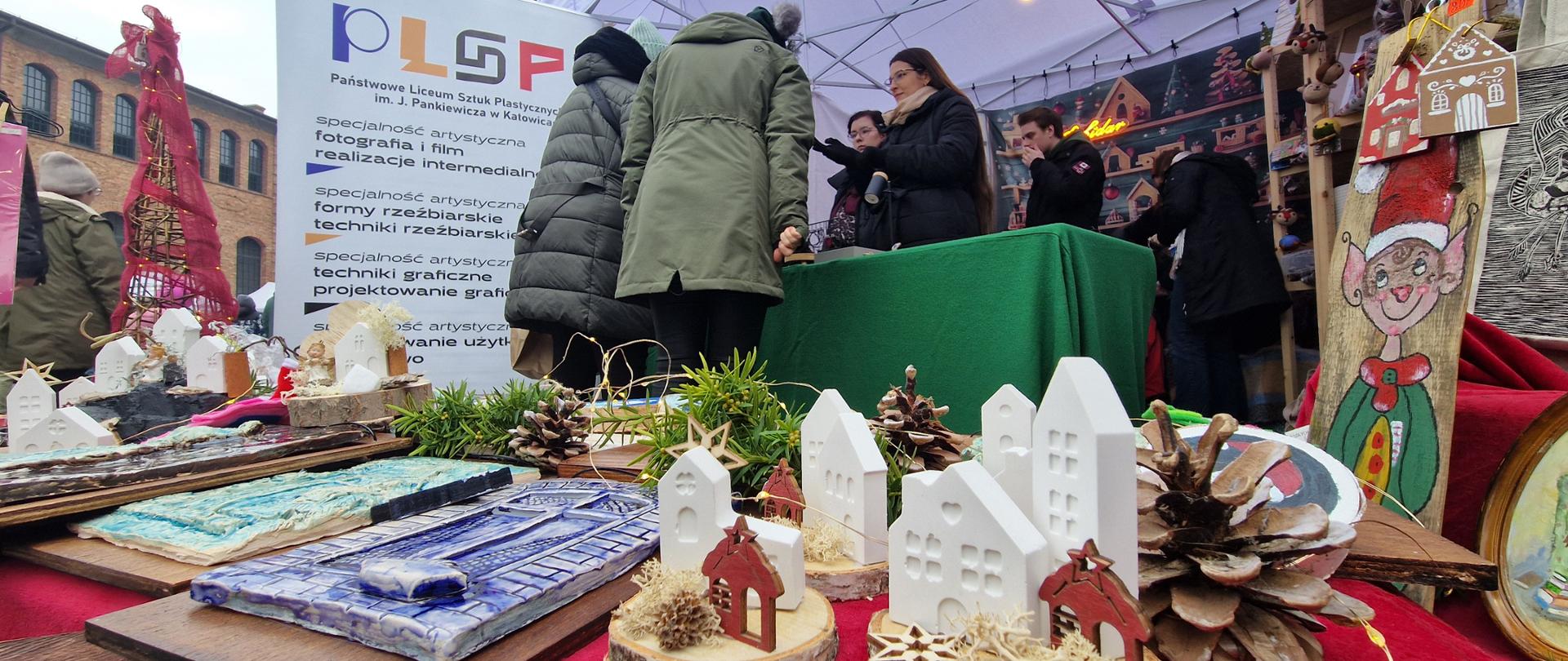 Fotografia z Jarmarku na Nikiszu przedstawiająca stoisko oraz uczestników wydarzenia