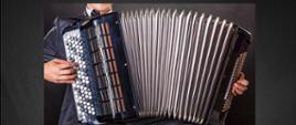 Koncert muzyki akordeonowej. 23 stycznia 2023, godz. 16.00. Czarne tło, akordeonista na zdjęciu. 