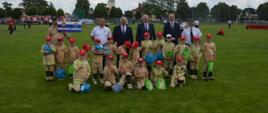 XI Powiatowe Zawody Sportowo-Pożarnicze OSP i MDP. Stadion w Miejskiej Górce. Na murawie boiska do wspólnego zdjęcia pozują członkowie DDp wraz z władzami państwowymi samorządowymi.