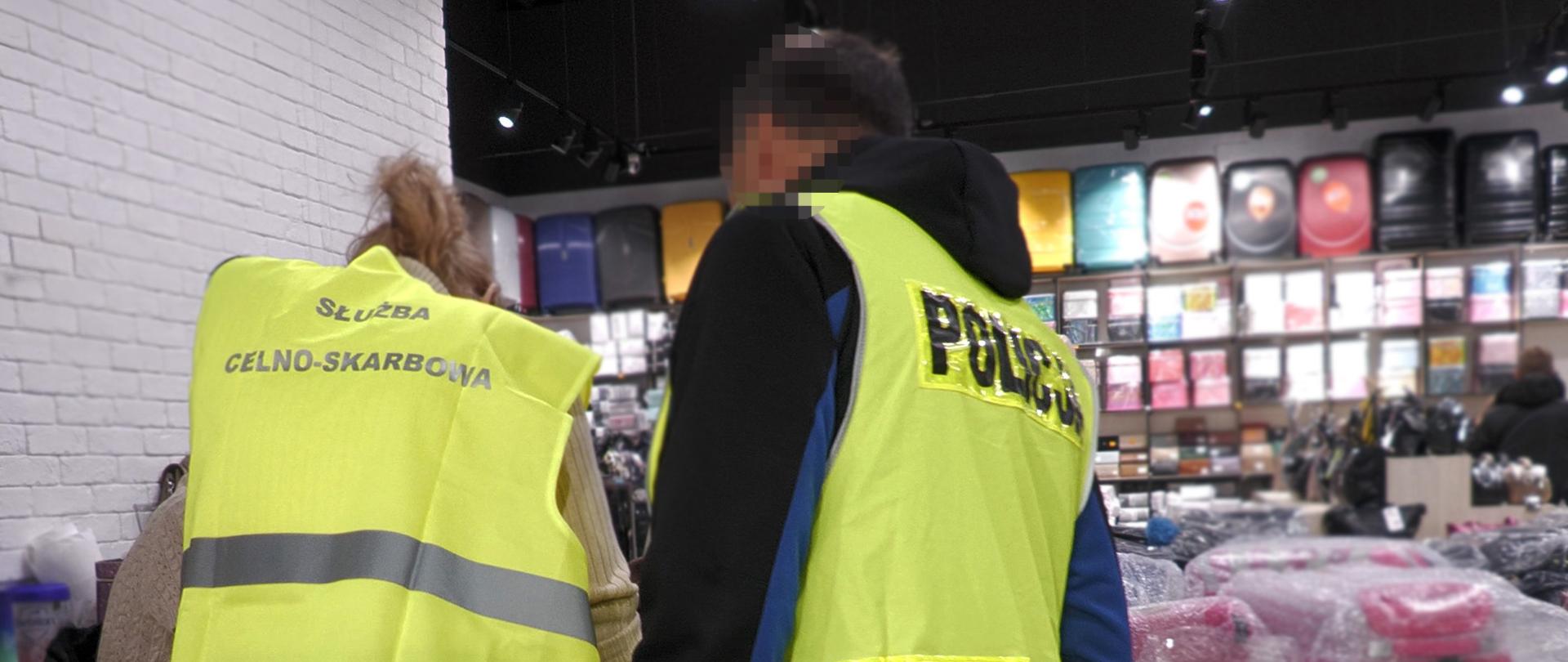 Funkcjonariusze Służby Celno-Skarbowej i Policji podczas sprawdzania podrobionych towarów.