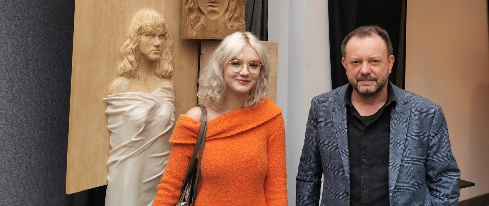 Na zdjęciu centralnie Karolina Czernik - Laureatka I Ogólnopolskiego Biennale Form Rzeźbiarskich i Użytkowych w Rzeszowie oraz pan Andrzej Mrowca - artysta rzeźbiarz, opiekun artystyczny Karoliny. Na drugim planie po lewej stronie usytuowana jest wyróżniona rzeźba zbudowana z pięciu płaskich elementów. Na każdym z elementów wykonane są płaskorzeźby - autoportrety. 