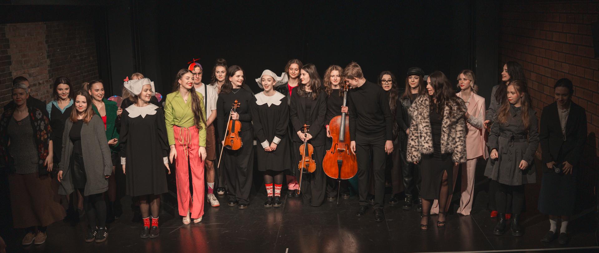 Uczniowie pierwszego roku stoją na scenie po wykonaniu spektaklu pt."Złote śledztwo"