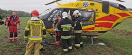 Śmigłowiec Lotniczego Pogotowia Ratunkowego wraz ratownikami medycznymi i strażakami.
