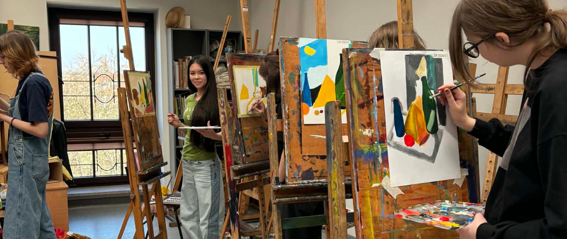 W pracowni malarstwa, uczniowie malują na papierze prace konkursowe – martwą naturę przy sztalugach