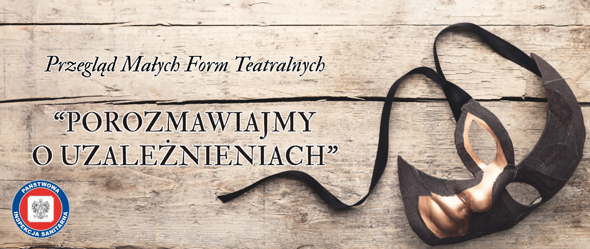 Grafika zapowiadająca Przegląd Małych Form Teatralnych „Porozmawiajmy o uzależnieniach”. Na drewnianym tle leży maska teatralna, w rogu widnieje logo Państwowej Inspekcji Sanitarnej.