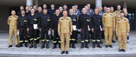 Grupowe zdjęcie uczestników szkolenia (23 funkcjonariuszy) w towarzystwie Zastępcy Komendanta Centralnej Szkoły PSP, kobiety oraz pięciu funkcjonariuszy CS PSP