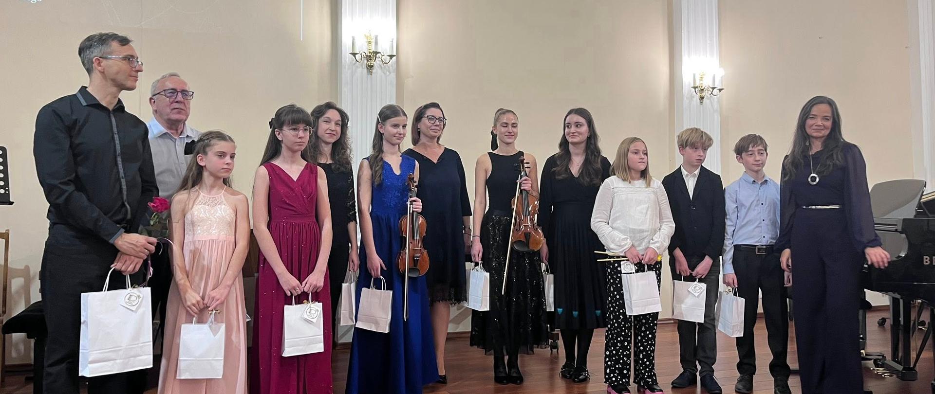 Pani Dyrektor Sonia Wachowska z zaproszonymi gośćmi i wykonawcami podczas Koncertu „W odcieniach szmaragdu” na scenie koncertowej Państwowej Szkoły Muzycznej w Lublińcu