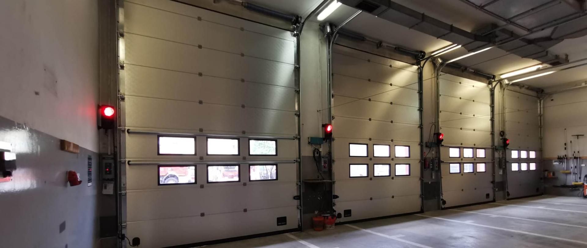 Zdjęcie przedstawia nowe bramy garażowe w chodzieskiej komendzie.
W tle budynek komendy.
