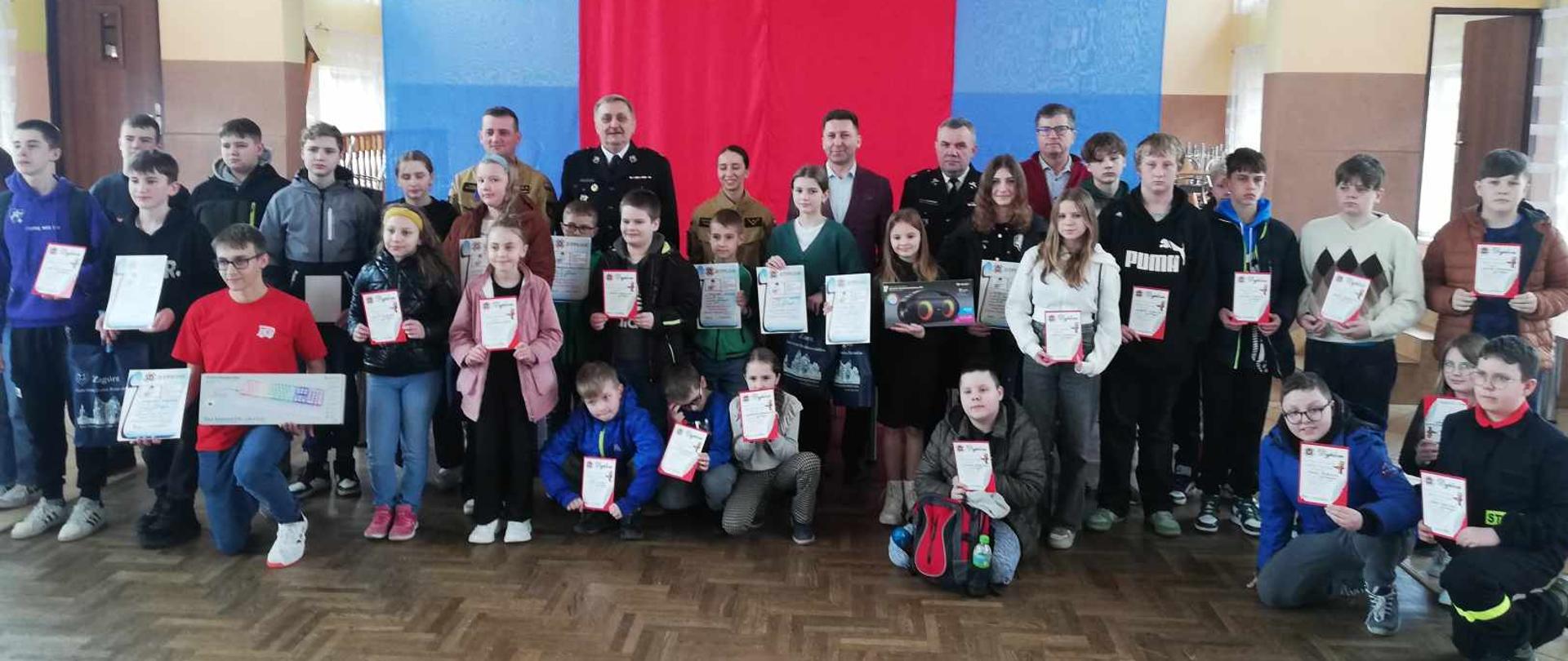 Zdjęcie grupowe wszystkich uczestników wykonane wewnątrz pomieszczenia. Na zdjęciu około 30 osób 