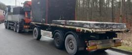 Samochód ciężarowy z podpiętą naczepą przewozi dwa szamba betonowe z pokrywami. Zespół pojazdów jest za ciężki i za długi.
