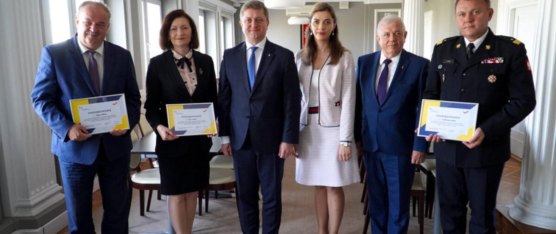 Grupa osób w sali kolumnowej Podkarpackiego Urzędu Wojewódzkiego w Rzeszowie 