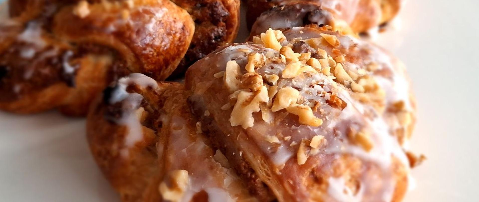 Zdjęcie przedstawia rogal w kształcie półksiężyca i z orzechową posypką