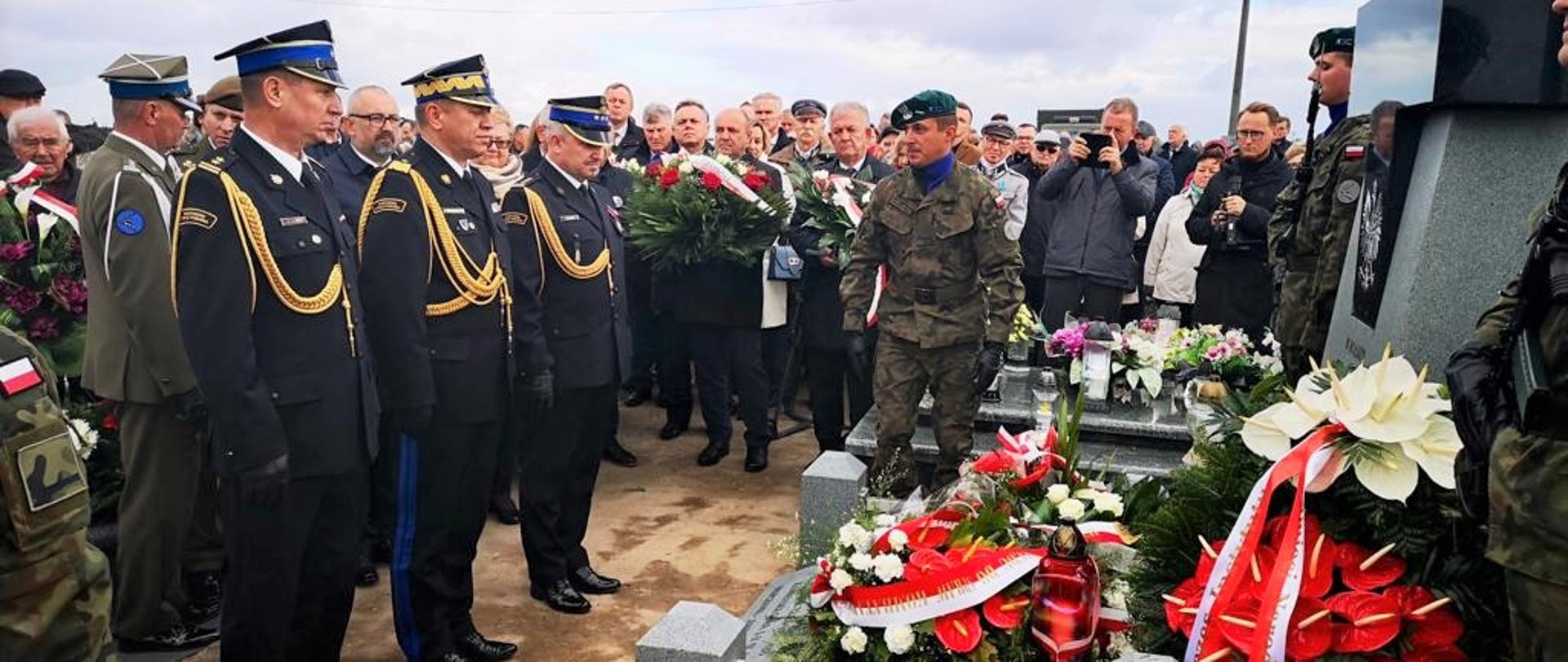 W dniu 2 października 2022 roku w Pawłowie Kościelnym, gmina Czernice Borowe, powiat Przasnyski odbyła się uroczystość odsłonięcia pomnika „Bohaterom Niepodległości w hołdzie obrońcom Ojczyzny i wszystkim naszym rodakom poległym i pomordowanym w walce z niemieckim i sowieckim najeźdźcą w latach 1918 – 1956”. Uroczystość zorganizowana została przez Instytut Pamięci Narodowej i Społeczny Komitet Upamiętnień Bohaterów Niepodległości oraz powiaty przasnyski i mławski, a także gminy Czernice Borowe i Dzierzgowo pod patronatem narodowym Prezydenta Rzeczypospolitej Polskiej Pana Andrzeja Dudy.
Uroczystość rozpoczęła się od koncertu pieśni patriotycznych w wykonaniu Orkiestry Dętej z Dzierzgowa. Następnie została odprawiona Msza Święta za Ojczyznę oraz Bohaterów Niepodległości koncelebrowana pod przewodnictwem JE Księdza Biskupa Mirosława Milewskiego. Po uroczystościach mszalnych nastąpił przemarsz na cmentarz parafialny gdzie zostały złożone urny z ziemią, nastąpiło odsłonięcie pomnika Bohaterów Niepodległości, poświęcenie tablicy, odczytano apel pamięci i salwa honorowa będącej na miejscu kompanii reprezentacyjnej 2 Przasnyskiego Ośrodka Radioelektrycznego, a także został oddany hołd przez licznie przybyłe na uroczystość poczty sztandarowe.
Uroczystości zakończyły się piknikiem militarnym 2 Przasnyskiego Ośrodka Radioelektronicznego i Stowarzyszeń rekonstrukcyjnych północnego Mazowsza oraz poczęstunkiem na placu przy plebanii.
W uroczystościach udział wzięli między innymi:
- Pan Henryk Kowalczyk – Wicepremier i Minister Rolnictwa i Rozwoju Wsi,
- Pani Anna Ewa Cicholska –Poseł na Sejm RP,
- Pan Jan Maria Jackowski – Senator RP,
- JE Ksiądz Mirosław Milewski – Biskup płocki,
- Pan Adam Siwek – Dyrektor Biura Upamiętnień Walk i Męczeństwa Instytutu Pamięci Narodowej,
- Pan nadbryg. Jarosław Nowosielski – Mazowiecki Komendant Wojewódzki,
- Pani Anna Żebrowska – Kierownik Delegatury MUW w Ciechanowie,
- Pan Krzysztof Bieńkowski – Starosta przasnyski,
- Pan Jerzy Rakowski – Starosta mławski,
- Pan Andrzej Cześnik – Starosta sierpecki,
- przedstawiciele samorządów gminnych z Czernic Borowych i Dzierzgowa, służb mundurowych, licznie zgromadzonych stowarzyszenia i organizacji społecznych, a także społeczność lokalna.
Opracowanie: kpt. Piotr Kuligowski – Komenda Powiatowa PSP w Przasnyszu.
Zdjęcia: Starostwo Powiatowe w Przasnyszu, 2. Ośrodek Radioelektroniczny w Przasnyszu.
