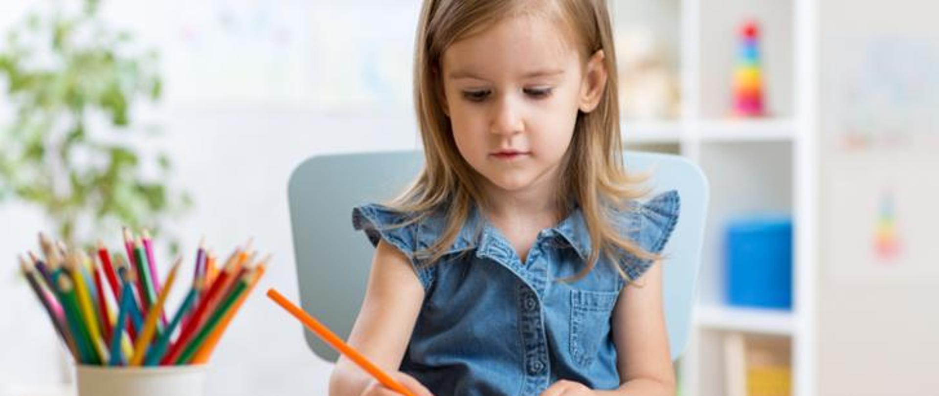 Zdjęcie przedstawia dziewczynkę, uczennice odrabiającą zadania szkolne. 