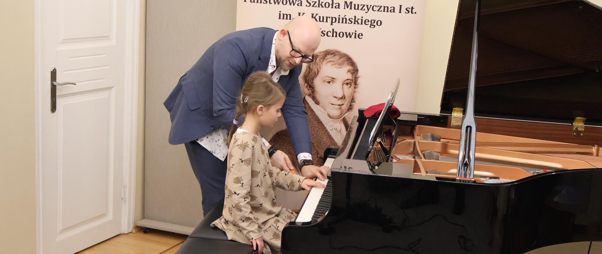 Prowadzący warsztaty podczas udzielania wskazówek uczennicy.