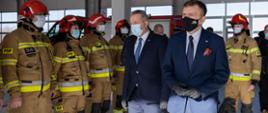 Minister Łukasz Schreiber i wojewoda Mikołaj Bogdanowicz przechodzą przed strażakami w szyku
