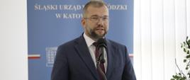 Minister Grzegorz Puda stoi i przemawia do mikrofonu