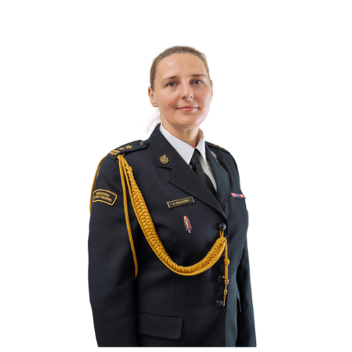 Na zdjęciu znajduje się kobieta w spiętych włosach i mundurze wyjściowym Państwowej Straży Pożarnej, mająca przepasany przez prawe ramię złoty sznur.