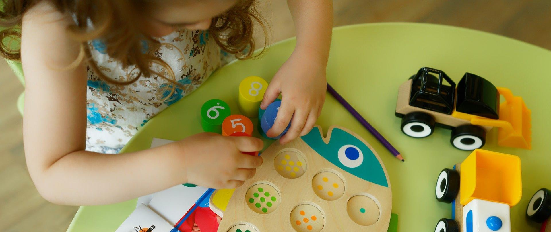 Dziecko podczas zabawy - układa układankę