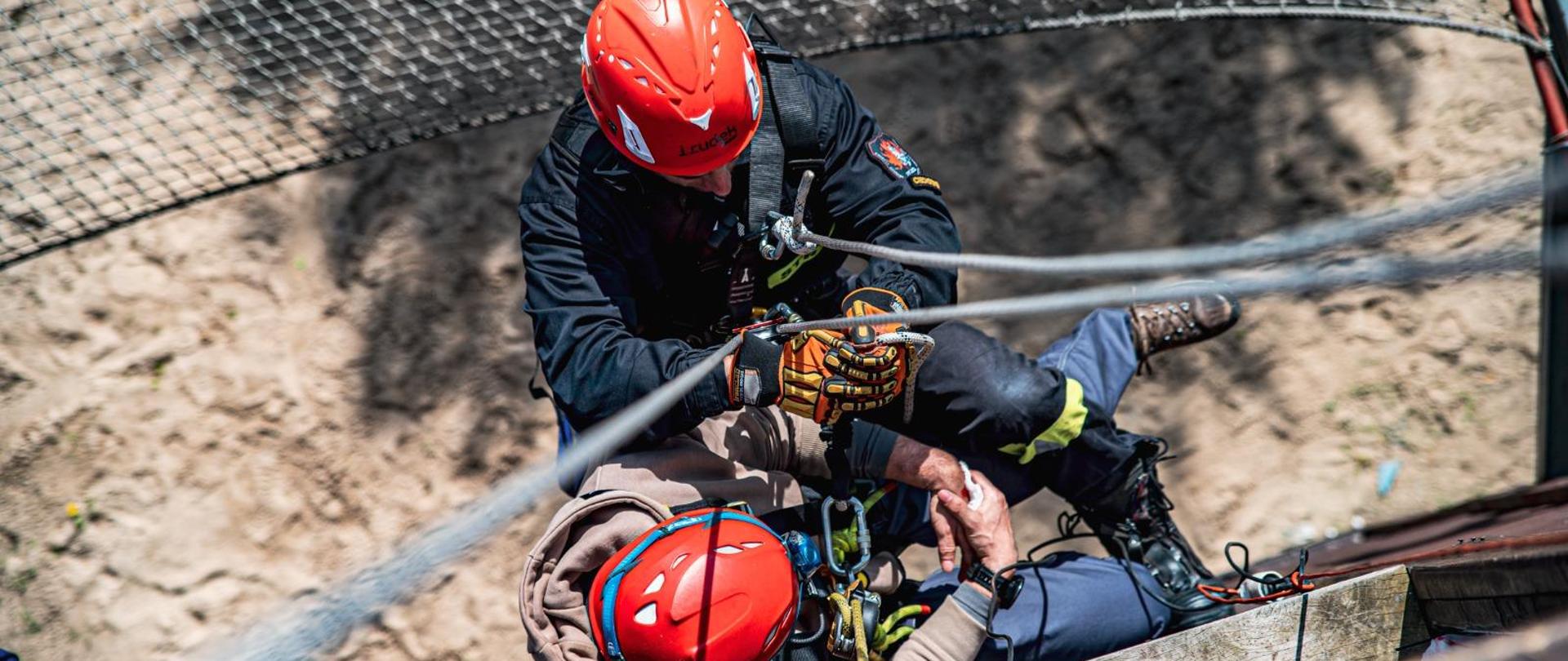 Strażak podczas zjazdu na ścianie wspinalni do poszkodowanego