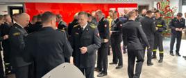 strażacy KP PSP łamią się opłatkiem i składają sobie życzenia