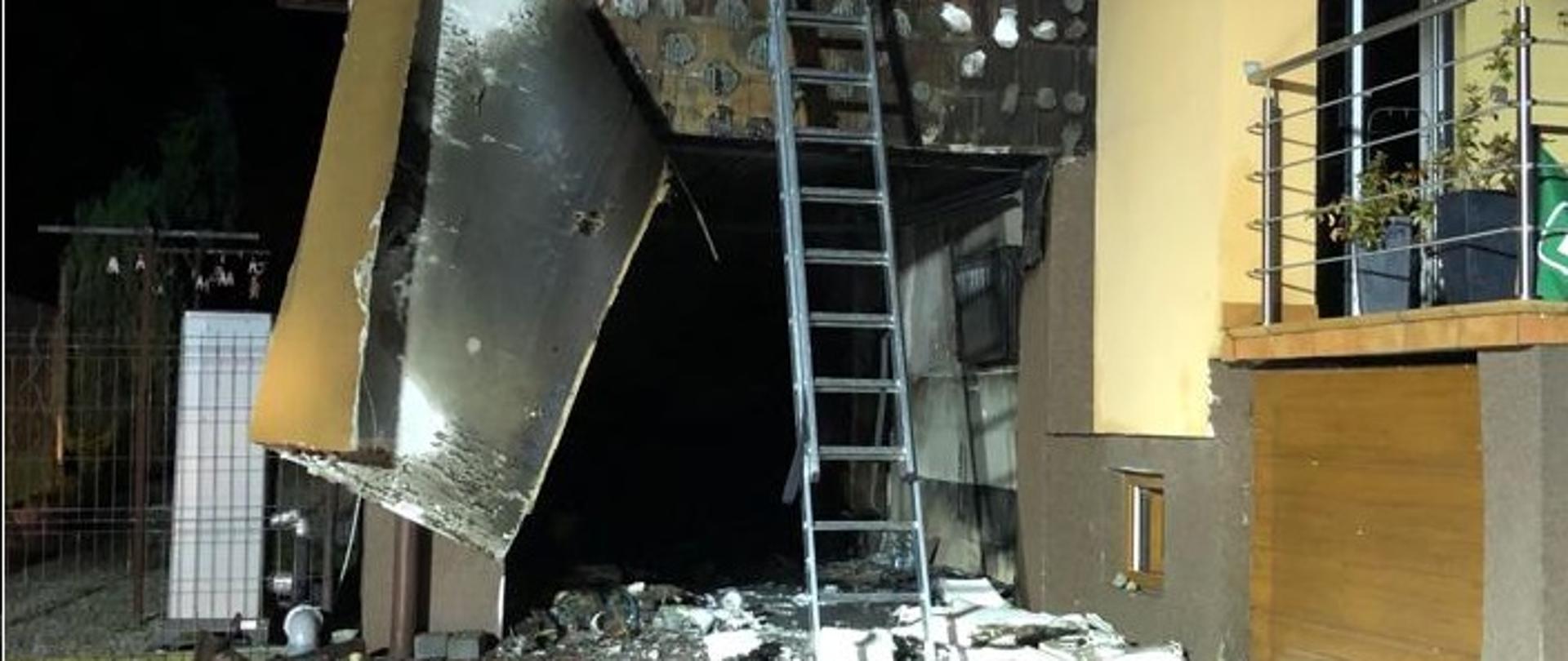 Zdjęcie przedstawia garaż w budynku mieszkalnym zniszczony przez pożar. 