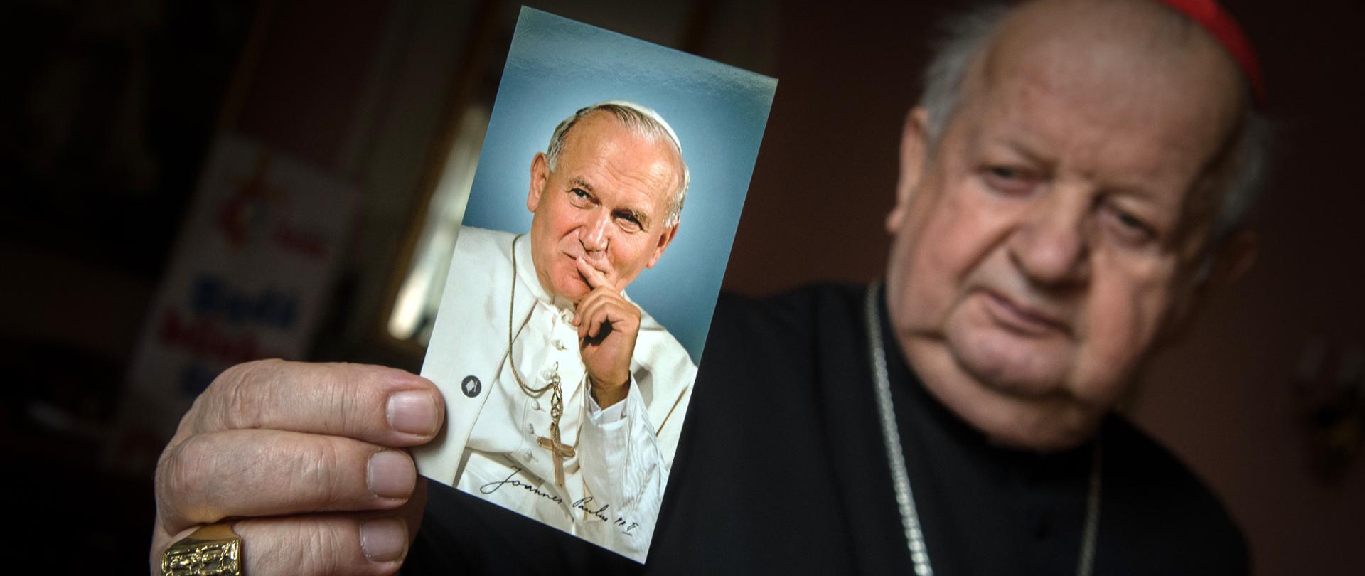 Cardinal Stanisław Dziwisz. Secretary of Pope John Paul II. Archbishop Emeritus of the Archdiocese of Cracow. He is holding in an outstreched hand a photo of Pope John Paul II