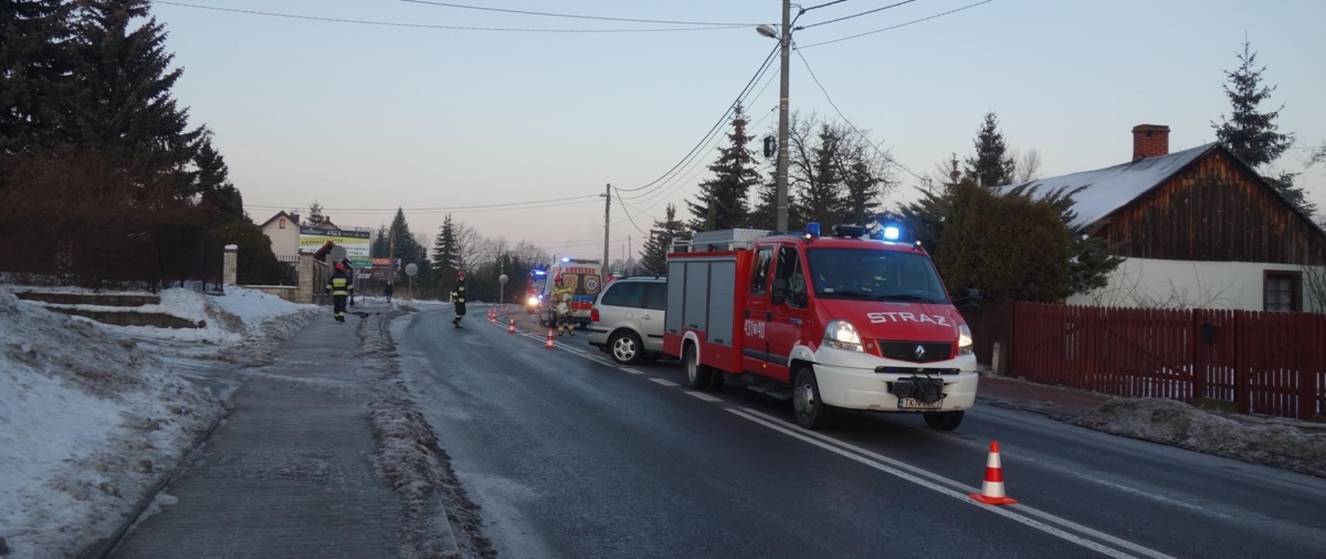 Na prawym pasie jezdni na zakręcie stoją samochody działających służb i pojazdy które brały udział w zdarzeniu
