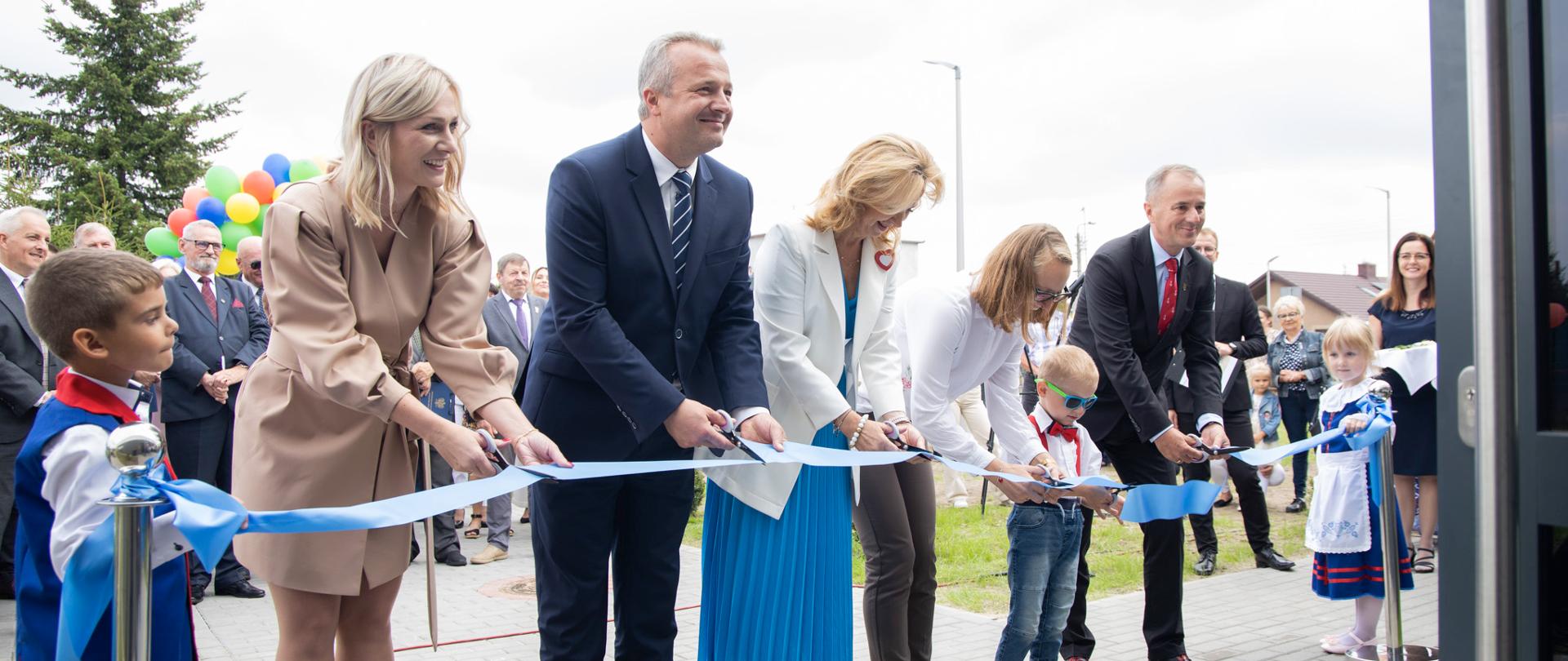 
Grupa ludzi w garniturach stojąca przed mikrofonem
