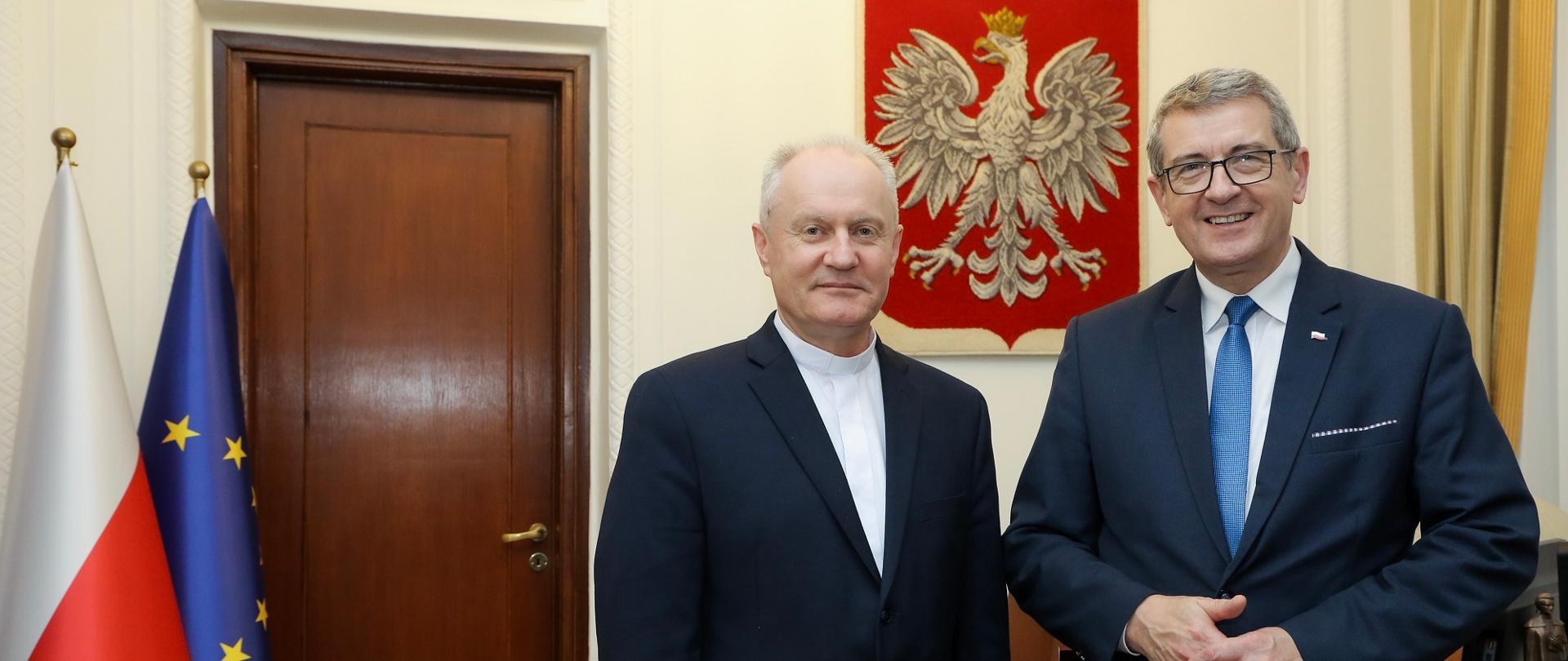 Minister i rektor stoją obok siebie w gabinecie.