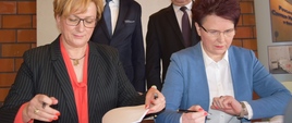 Na zdjęciu wiceminister Józefa Szczurek-Żelazko oraz prezes Zarządu Powiatowego Centrum Medycznego w Grójcu Marzena Jadwiga Barwicka podpisują umowę na dofinansowanie. W tle marszałek Senatu Stanisław Karczewski oraz starosta powiatu Marek Ścisłowski.